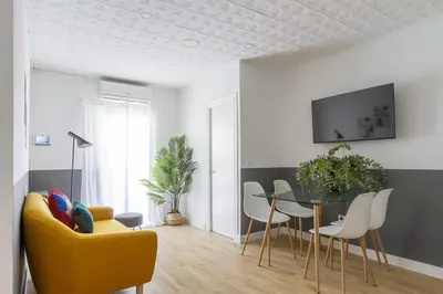 a living room with a yellow couch and a table at Feel Welcome Barcelona # SPLAU in Cornellà de Llobregat