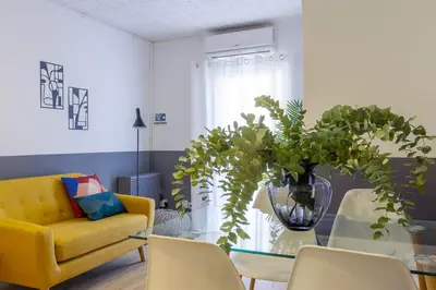 a living room with a yellow couch and a glass table at Feel Welcome Barcelona # SPLAU in Cornellà de Llobregat