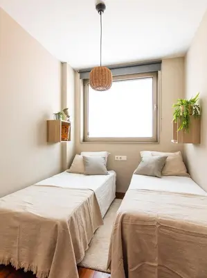 two beds in a room with a window at Homing Barcelona 101 in Hospitalet de Llobregat