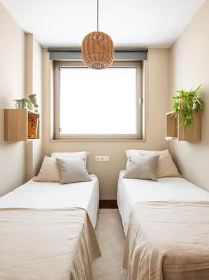 two beds in a room with a window at Homing Barcelona 101 in Hospitalet de Llobregat