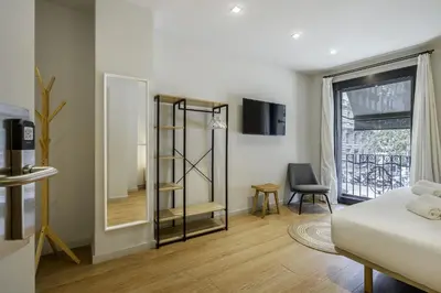 a room with a bed and a mirror and a window at Ola Living Hostal Diagonal in Barcelona