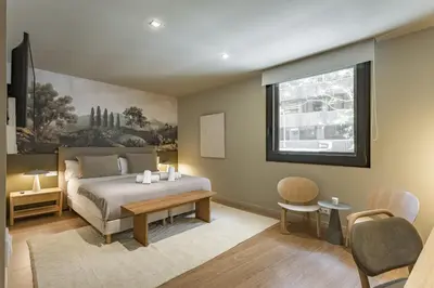 a bedroom with a bed and a table and a window at Ola Living Hostal Diagonal in Barcelona