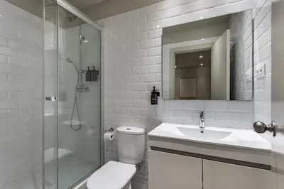 a bathroom with a toilet and a sink and a shower at Ola Living Hostal Diagonal in Barcelona