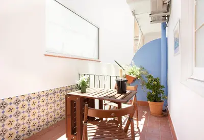 a small balcony with a wooden table and chairs at Centric Apartment El Molino Theater p1 in Barcelona