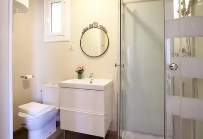 a white bathroom with a toilet and a mirror at Centric Apartment El Molino Theater p1 in Barcelona