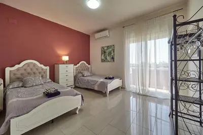a bedroom with two beds and a large window at Villa Soledad en Olivella, Sitges, Barcelona in Olivella