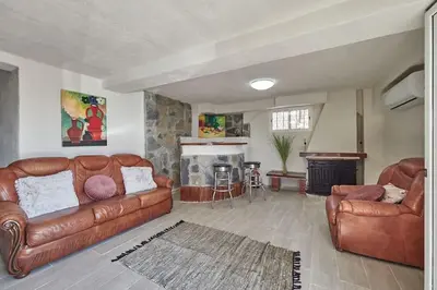 a living room with two leather couches and a fireplace at Villa Soledad en Olivella, Sitges, Barcelona in Olivella