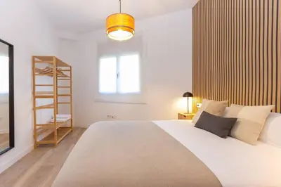 a bedroom with a large white bed and a television at Duplex with terrace near Bcn in Terrassa