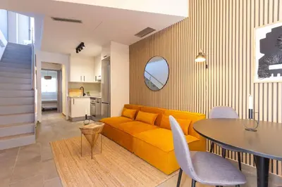 a living room with a yellow couch and a table at Duplex with terrace near Bcn in Terrassa