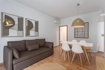 a bedroom with two beds and a chandelier at Ola Living Sagrada Familia in Barcelona