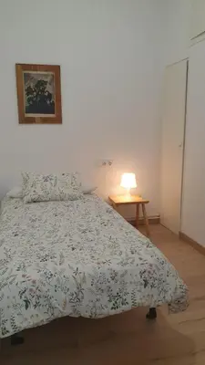 a bedroom with a bed and a lamp on a table at Apartamento nuevo en Terrassa Centro in Terrassa