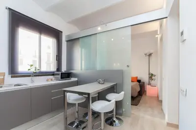 a kitchen with a table and two stools at Housalia Sant Pau Views- Suite with View on Hospital Sant Pau in Barcelona