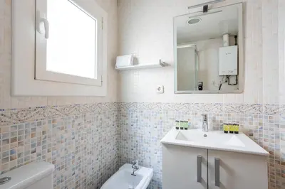 a white bathroom with a sink and a mirror at Housalia Lepant 3 bedroom apartment 300 meters de Sagrada Familia in Barcelona