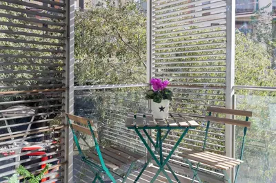 a table with a vase of flowers on a balcony at Marion House Barcelona in Barcelona