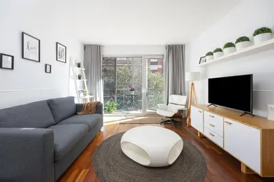 a living room with a couch and a tv at Marion House Barcelona in Barcelona