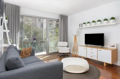 a living room with a couch and a tv at Marion House Barcelona in Barcelona