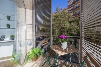 a small balcony with a table and flowers on it at Marion House Barcelona in Barcelona