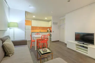 a living room with a table and chairs and a kitchen at Housalia Corsega - Apartment 3 bedrooms next to Sagrada Familia in Barcelona