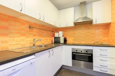 a kitchen with white cabinets and a sink at Housalia Corsega - Apartment 3 bedrooms next to Sagrada Familia in Barcelona