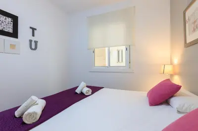 a bedroom with a large bed with purple and white towels at Housalia Corsega - Apartment 3 bedrooms next to Sagrada Familia in Barcelona