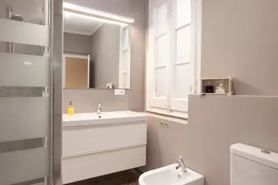 a white bathroom with a sink and a toilet at Enjoy Apartments Sofia in Barcelona