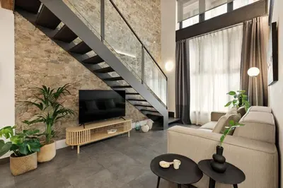 a living room with a television and a staircase at Ola Living MACBA in Barcelona