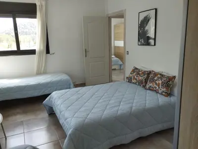 a bedroom with two beds and a window at Villa Franz House Casa Principal in Canyelles