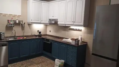 a kitchen with blue cabinets and white appliances at Villa Franz House Casa Principal in Canyelles