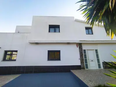 a white house with black windows at Villa Franz House Casa Principal in Canyelles