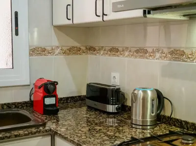a kitchen with a counter top with a toaster and a microwave at Apartamento al lado Del Mar in Sant Adria de Besos