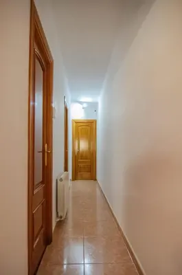 an empty hallway with a wooden door and a hallwayngth at Apartamento al lado Del Mar in Sant Adria de Besos