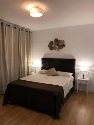 a bedroom with a large bed and two lamps at Apartamento al lado Del Mar in Sant Adria de Besos