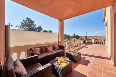 a patio with a couch and tables on a balcony at Villa lluna en Olivella, Sitges, Barcelona in Olivella
