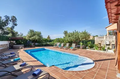 a swimming pool with lounge chairs next to a house at Villa lluna en Olivella, Sitges, Barcelona in Olivella