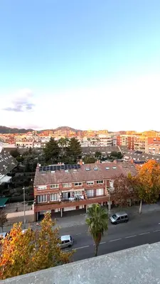 a building with cars parked in a parking lot at Dúplex con terraza by Prestigi in Terrassa