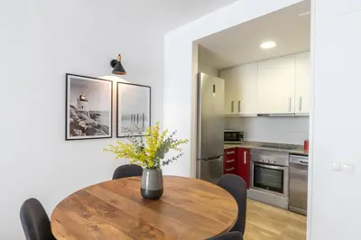 a kitchen and dining room with a wooden table and chairs at The Orbit Apartments in Barcelona