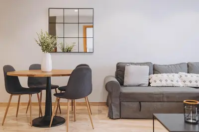 a living room with a couch and a table and chairs at The Orbit Apartments in Barcelona