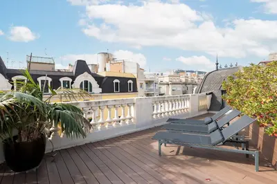 a balcony with a bench on top of a building at Enjoy Apartments La Riera Penthouse in Barcelona