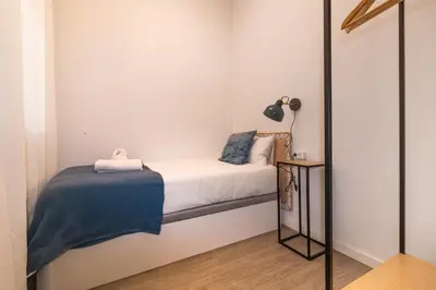 a small bedroom with a bed and a mirror at Central & Fully Equipped Apartment in Eixample Next to Metro, Sleeps 5 in Barcelona