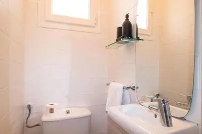 a bathroom with a sink and a toilet and a window at Central & Fully Equipped Apartment in Eixample Next to Metro, Sleeps 5 in Barcelona
