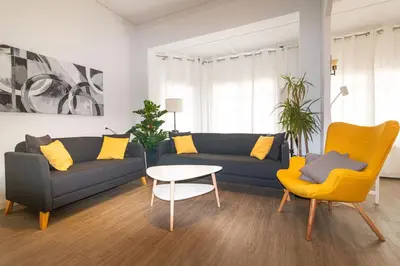 a living room with a couch and a table and chairs at Central & Fully Equipped Apartment in Eixample Next to Metro, Sleeps 5 in Barcelona