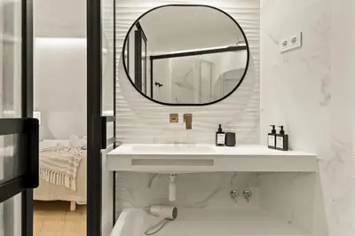 a white bathroom with a sink and a mirror at Modern & stylish apartment in Barcelona in Barcelona