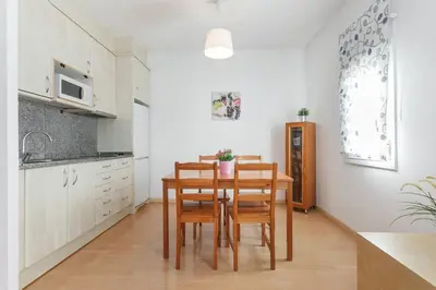 a kitchen with a table and chairs in a room at ApartEasy - Lightly, central and quiet apartment in Barcelona