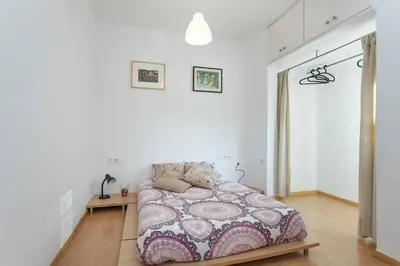 a white bedroom with a bed in a room at ApartEasy - Lightly, central and quiet apartment in Barcelona