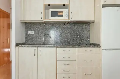 a kitchen with a sink and a microwave at ApartEasy - Lightly, central and quiet apartment in Barcelona
