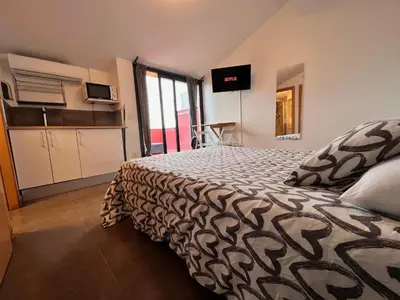 a bedroom with a bed and a desk and a window at MT Boutique Suites y Apartamentos - Adults Only - in Mataró