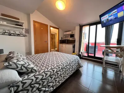 a small kitchen with brown cabinets and a microwave at MT Boutique Suites y Apartamentos - Adults Only - in Mataró