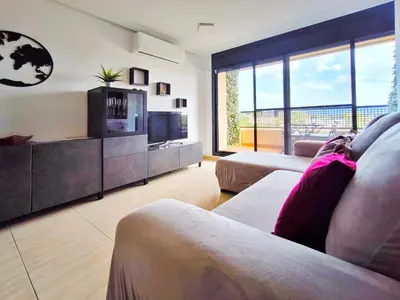 a living room with a couch and a television at Duplex con piscina en Rubí in Rubí