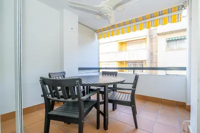 a table and chairs in a room with a balcony at HomeHolidaysRentals Deva - Costa Barcelona in Pineda de Mar