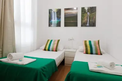 two beds in a room with green sheets at Elegance and Comfort in Barcelona, 4Bedroom Apartment in the Most Exclusive Area in Barcelona